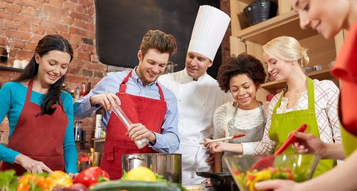 Employees learning how to cook with chef. 